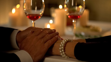 Aged male holding wife hands, married couple on romantic date, love expression