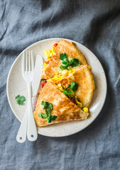 Scramble eggs vegetables ham quesadilla on a grey background, top view. Delicious appetizers, tapas, breakfast