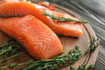 Raw salmon fillet on wooden board, closeup