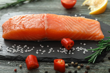 Raw salmon fillet on slate board