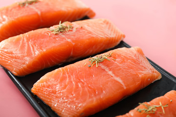 Plate with raw salmon fillet on color background, closeup