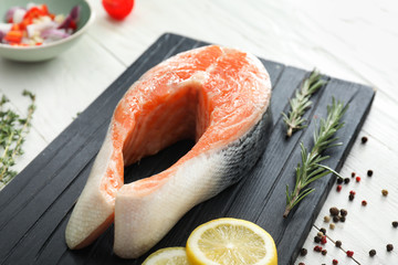 Raw salmon steak on wooden board