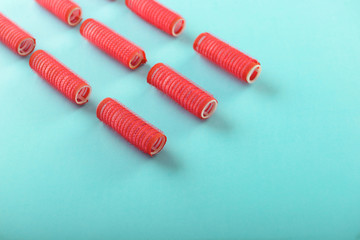 Fototapeta premium Hair curlers on color background