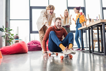 smiling casual business colleagues having fun and riding skateboard in loft office © LIGHTFIELD STUDIOS