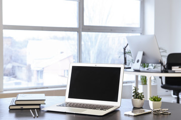 Comfortable workplace with modern laptop in office