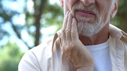 Dental pain, retired man suffering from toothache, teeth prosthetics, dentistry