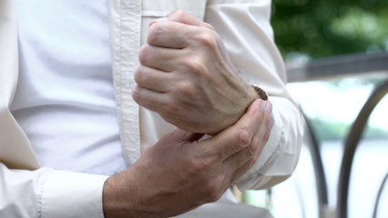 Senior man suffering pain in arm, problem with joint inflammatory arthritis