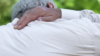 Senior man feeling pain in neck, rheumatism disease, physiotherapy, back view