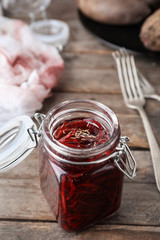 Jar with tasty fermented beetroot on wooden table
