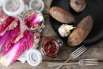 Jar with tasty fermented beetroot and vegetables on wooden table