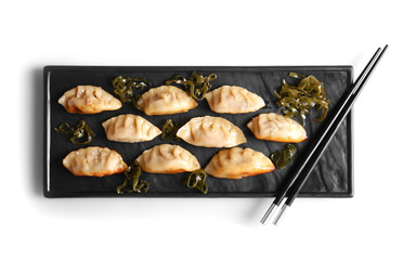 Plate with tasty Japanese gyoza on white background