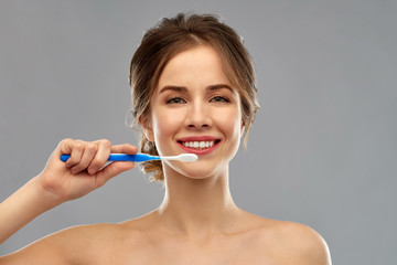 oral care, dental hygiene and people concept - smiling woman with toothbrush cleaning teeth over...
