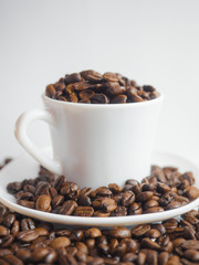 Coffee beans in coffee cup isolated on white