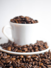 Coffee beans in coffee cup isolated on white