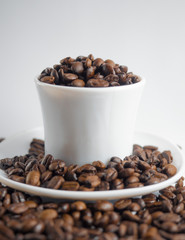Coffee beans in coffee cup isolated on white