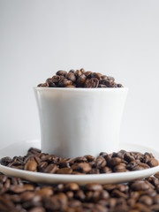 Coffee beans in coffee cup isolated on white