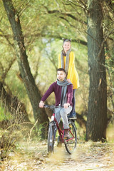 Fototapeta na wymiar Young happy couple on bicycle posing for camera