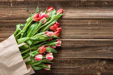 Fresh tulips. Colorful spring tulip bouquet, top view on wooden background. Mother's day or card for women's day.