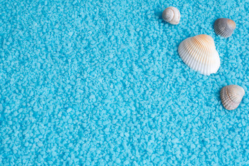 Ocean blue background with bath salt and sea shells, snail.