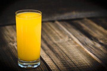Fresh juice in a glass. Orange juice on wood.