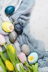 Bouquet of tulips with easter vintage eggs on a light gray background. Stylish Background with easter eggs, modern. Happy Easter card, spring flowers, copy space, space for text.