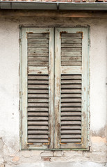 Old damaged wooden curtains or shades on abandoned house window vertical image