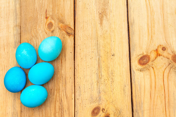 Easter concept with colorful eggs on wooden background, top view, copy space