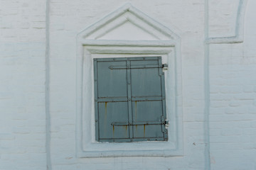 The White Brick Wall with the Closed Iron Window in Kolomenskoye, Moscow.