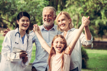 Happy healthy family and doctor talking in the park. People healthcare and medical staff service concept.