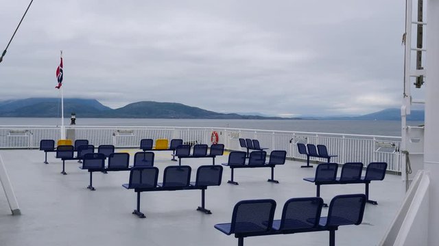 Ferry deck with empty seats and sea view in the background. Ferryboat ride route Bognes - Lodingen to Lofoten islands Norway. Tourism vacation and travel