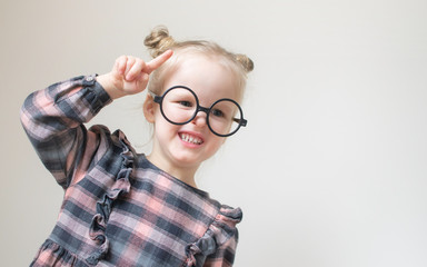 Caucasian little girl with round glasses. Little teacher. Funny glasses humor. Retro style