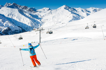 Fototapeta na wymiar Back view of skier woman enjoys the winter ski resort.
