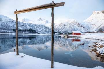  reflected house on Fiskefjorden (fjord) in winter season, Lofoten Islands, Norway