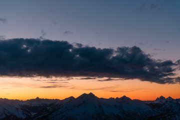 Amazing orange sunset over the snowy mountains. Zugspitze mountains in the evening. Bavarian Alps, Germany