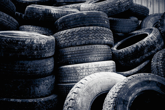 Heaps of discarded rubber auto tyres, waste dump or recycling operation