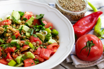 Plate with delicious lentils salad on wooden table