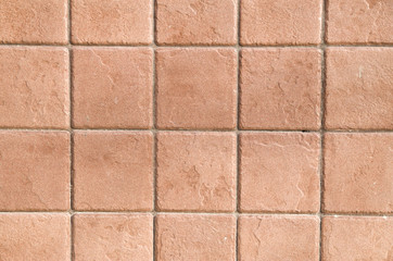 A wall lined with brown ceramic tiles