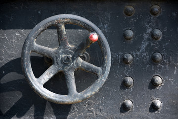 Flywheel with red handle of an old locomotive