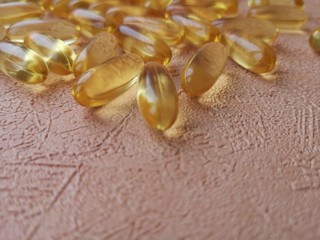 Close-up: transparent yellow capsules (pills) Omega 3 fish oil on a bright orange background