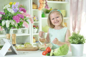 Portrait of cute little girl preparing salad