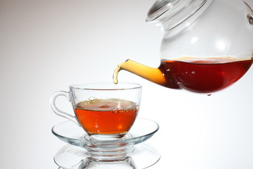 Pouring tea to a teacup.