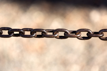 Thick iron chain stretching across a well lit space