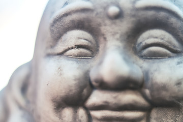 Defocused face of a smiling Buddha