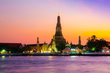 Fototapeta premium Famous wat temple in the downtown city center waterfront of Bangkok on the water river during sunset as part of children school holiday excursion exploration