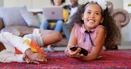 Front view of cute black siblings watching television in living room at comfortable home 4k