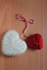 Fototapeta na wymiar Red and white heart made from woollen yarn and tied the knot.
