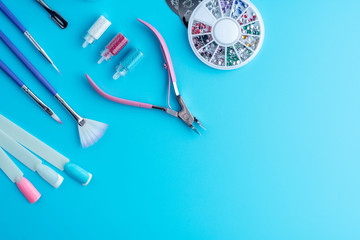 Set of cosmetic tools for professional manicure on a blue background. Composition with a place for text