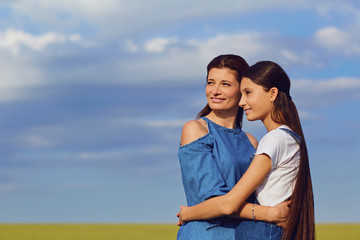 Obraz premium Mother and daughter teenager embrace in in nature.