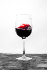 Red wine in the glass splashes in motion on a white background. Design card