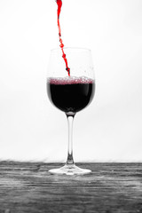 Red wine in the glass splashes in action on a white background. Design card